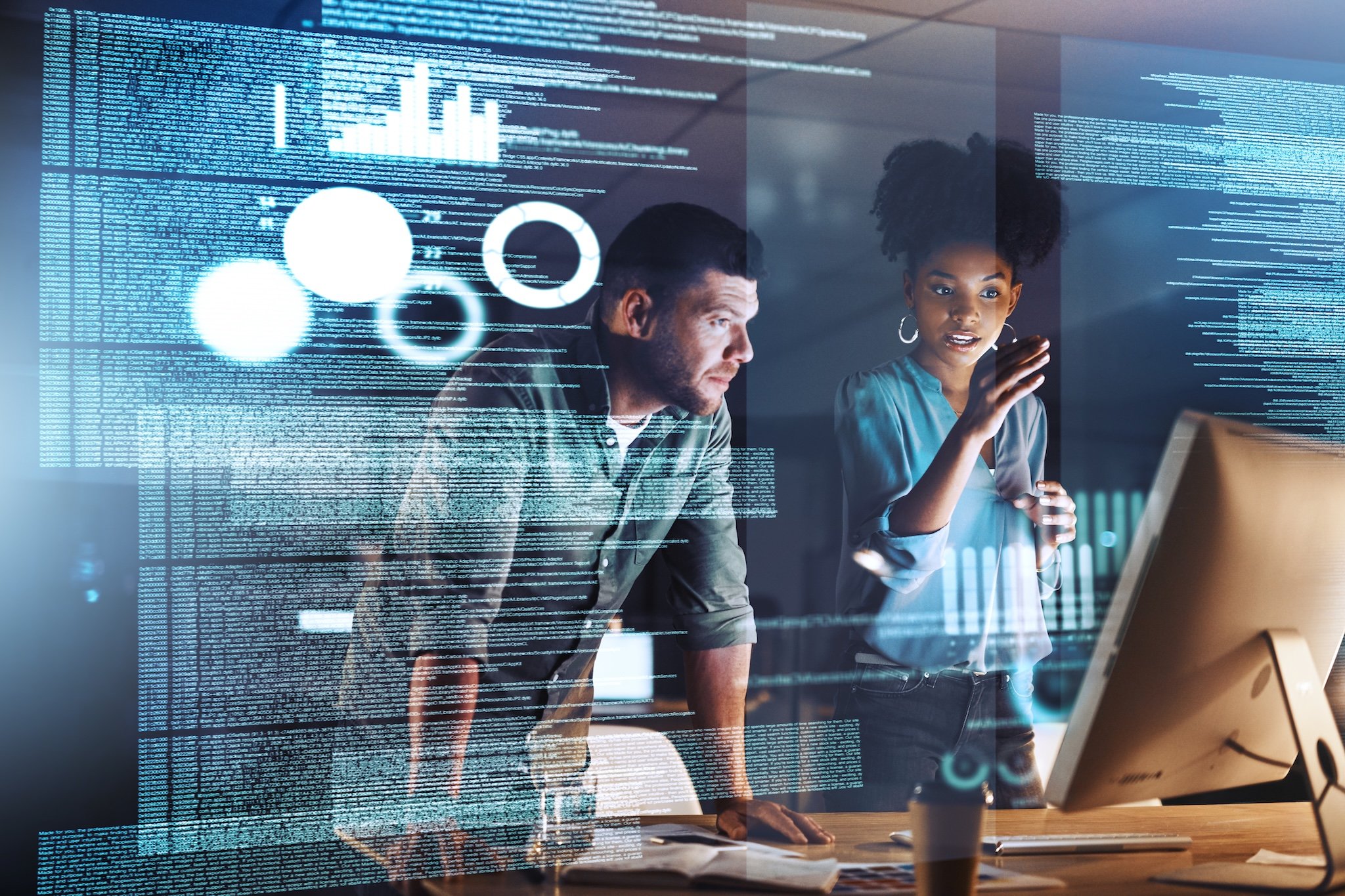 Man and woman looking at a computer screen with code. Software development and coding concept.