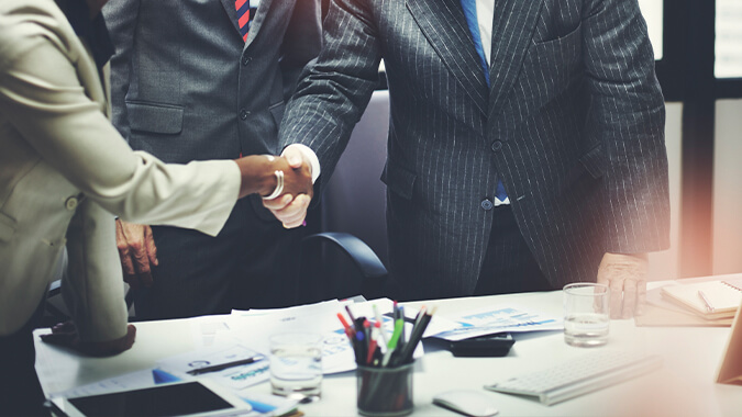 People shaking hands in an office setting.