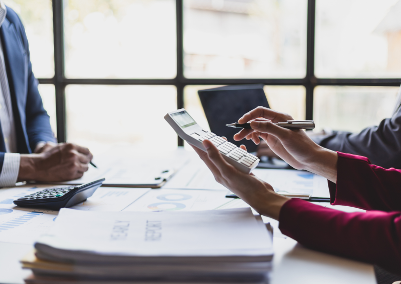 People calculating with calculator and documents in the office.