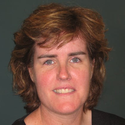 Portrait of a woman with blue eyes, short hair, and a smile.