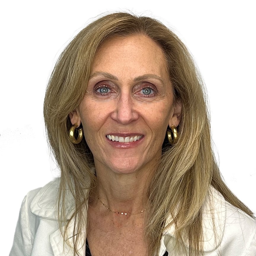 Blonde woman with blue eyes wearing a gold necklace and hoop earrings.