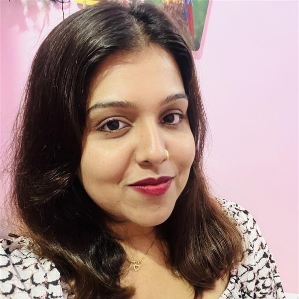 Woman with dark hair, a red lipstick, and a patterned top.