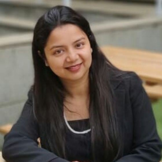 Portrait of a woman with dark hair wearing a black blazer.