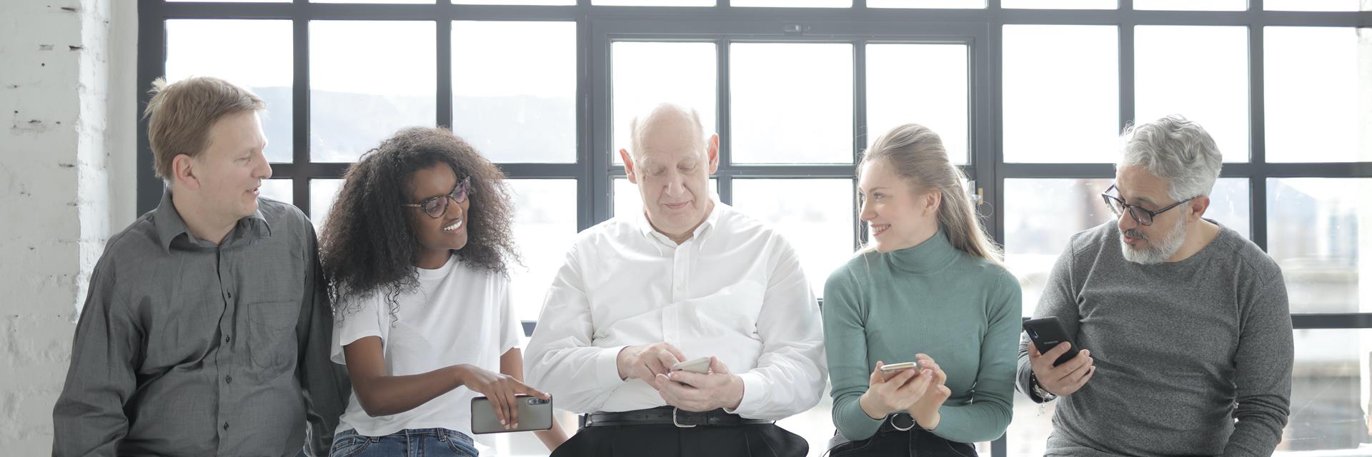 A Group Of People Sitting Beside A Steel Framed Window While 3863768